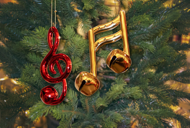 闪亮的红色高音谱号装饰和金色音乐音符与绿色圣诞树上的铃铛图片下载
