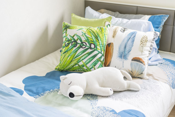 可爱的娃娃和许多彩色枕头在孩子的卧室。图片下载