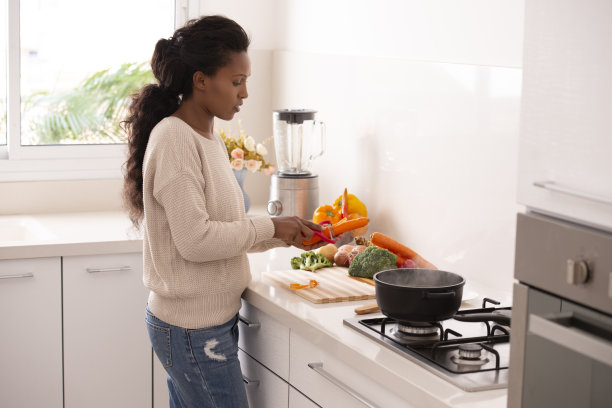 女人在厨房削胡萝卜准备做汤图片下载