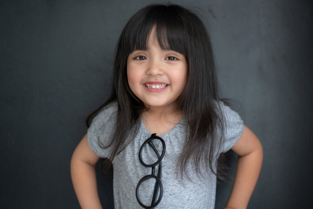 幸福黑头发亚洲大眼睛女孩肖像照片拍摄与休闲服装与有趣的黑色屏幕背景图片下载