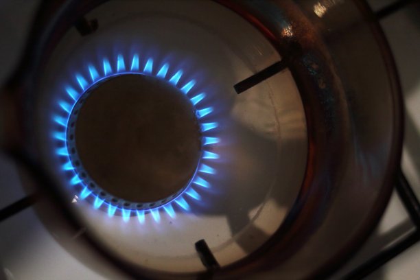 把玻璃杯里的水倒在燃烧的煤气上图片下载