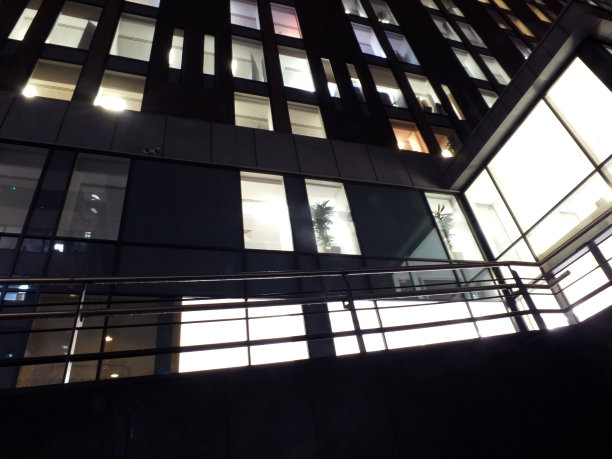 一幢大型办公楼的入口坡道和窗户在晚上灯火通明图片下载