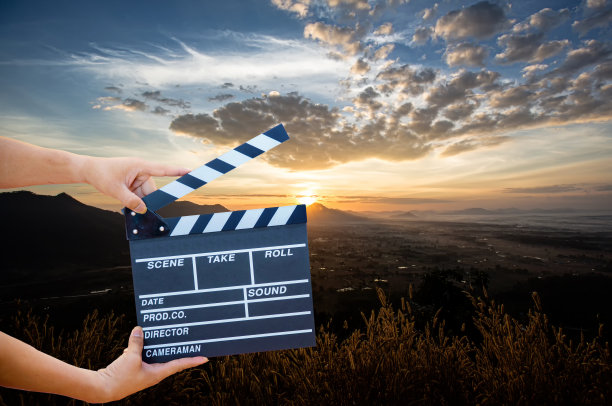 手握电影拍手孤立在自然背景下。显示板板。图片下载