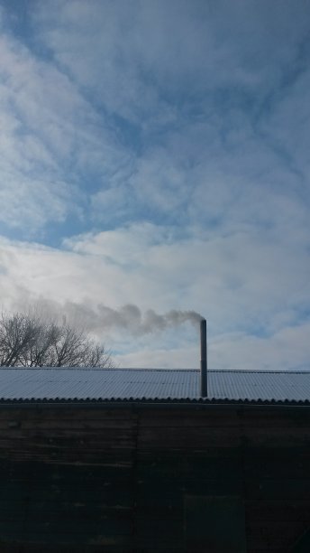 烟从管子里冒出来，为一所乡村房子供暖图片下载