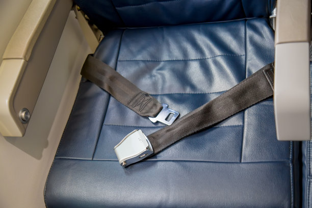 在一架空座位的飞机上，解开了安全带。安全的概念。图片下载