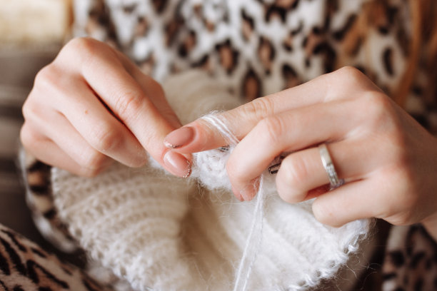 那个女人用手织毛线衣服。编织针。特写镜头。天然羊毛。水平的照片。自由职业，有创意的工作和生活理念图片下载