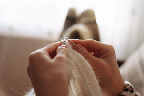 女人用手编织天然羊毛衣服。编织针特写。水平的照片。自由创造性的工作。手工艺的概念图片下载