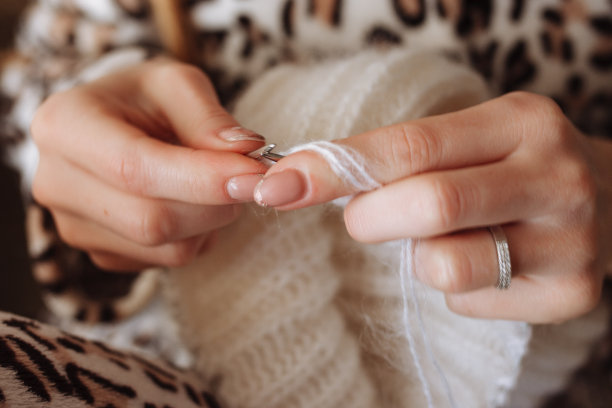 女人用手编织天然羊毛衣服。编织针特写。水平的照片。自由创造性的工作。手工艺的概念图片下载