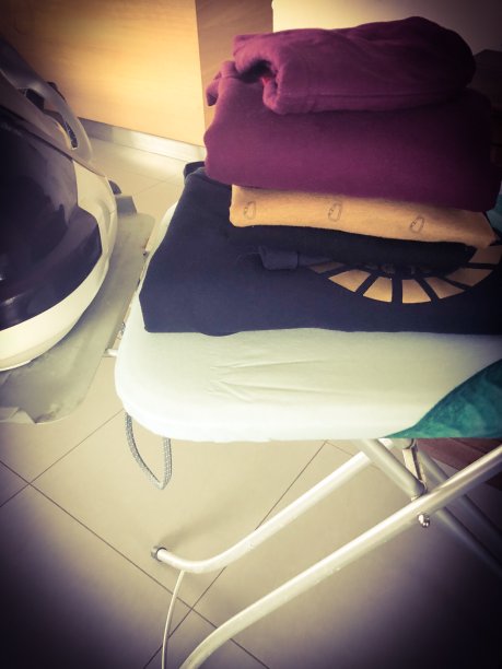 熨斗、熨衣板和一堆衣服图片下载