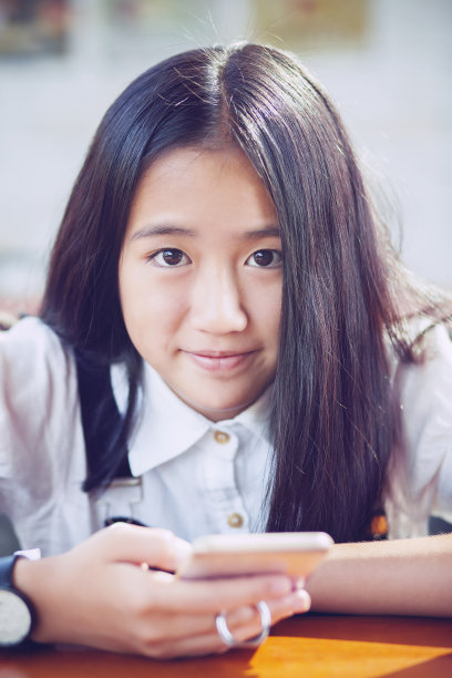 近距离观看亚洲青少年拿着智能手机的幸福笑脸图片下载
