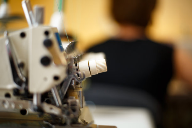 缝纫机锁边的特写细节。工作场所的裁缝。裁剪行业图片下载