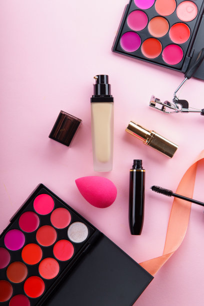 化妆品俯视图图片:口红调色板，粉底，睫毛膏和睫毛夹在粉红色的背景。化妆师套装概念图片下载