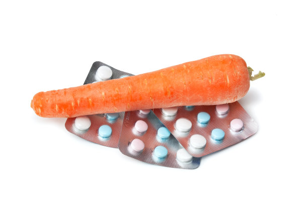 胡萝卜和含有维生素的包装被隔离在白色的背景上图片下载