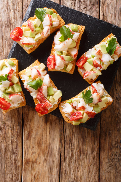 烤三明治，龙虾，鳄梨，西红柿和奶油芝士近距离摆在桌上。垂直俯视图，质朴图片下载