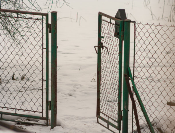 一扇古老的铁门在冬天打开图片下载