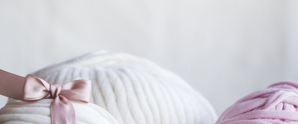 白色纱线与粉红色的蝴蝶结和带子，温柔和漂亮的简单的图片为手工材料。图片下载