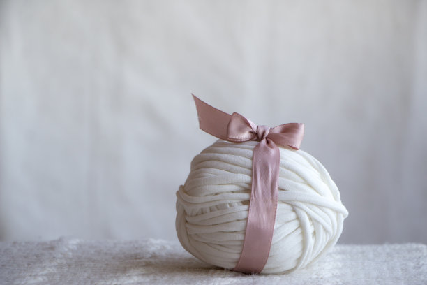白色纱线与粉红色的蝴蝶结和带子，温柔和漂亮的简单的图片为手工材料。图片下载