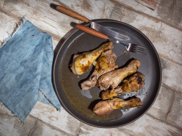 鸡腿放在灰色的圆盘子上，用微波炉加热图片下载
