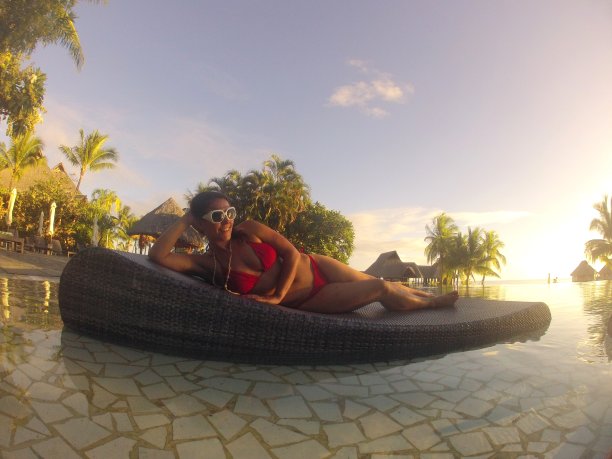 在波拉波拉岛度蜜月的女人懒洋洋地躺在游泳池旁，法属波利尼西亚图片下载