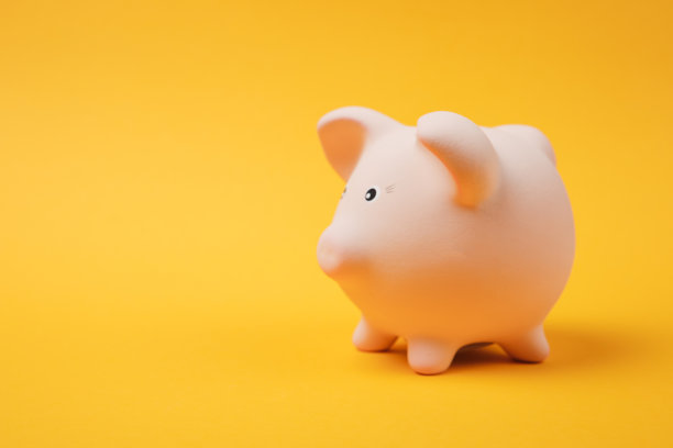 特写照片，侧面的粉红色存钱罐孤立在明亮的黄色墙壁背景。货币积累投资银行或商业服务财富概念。复制空间广告模拟。图片下载