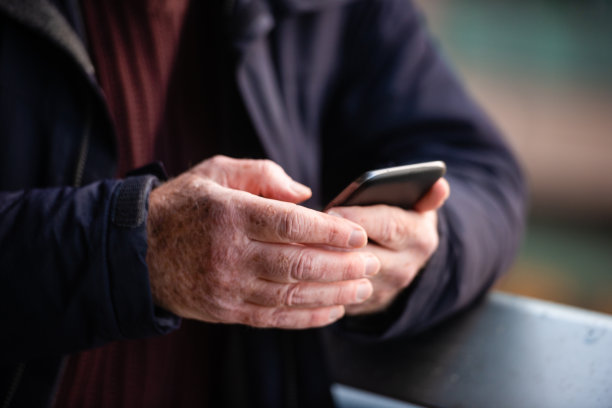 在美国纽约，高级男子的手在户外用手机发短信图片下载