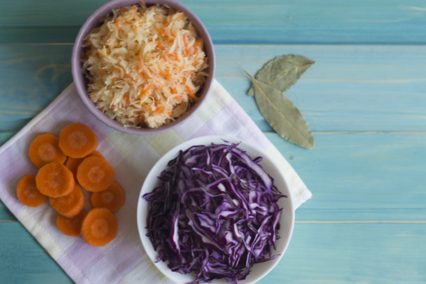 卷心菜和胡萝卜沙拉的照片和沙拉的紫色卷心菜在明亮的蓝色背景。图片下载