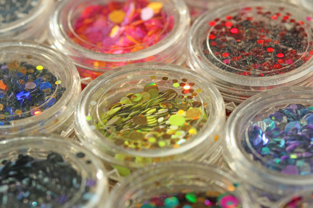 多色亮片设计的钉子在一个罐子。在jar闪闪发光。指甲用锡箔。组照片。闪闪美丽，闪闪发光。明亮的背景闪光。俯视图图片下载