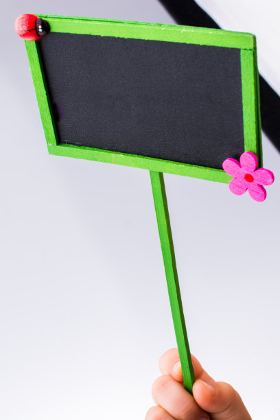 蹒跚学步的孩子拿着一个白色背景的布告栏图片下载