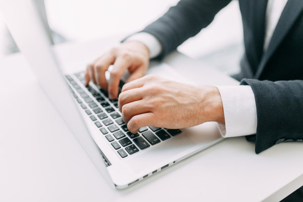 商业状况，孤立背景。在笔记本电脑上工作的手与散焦。图片下载