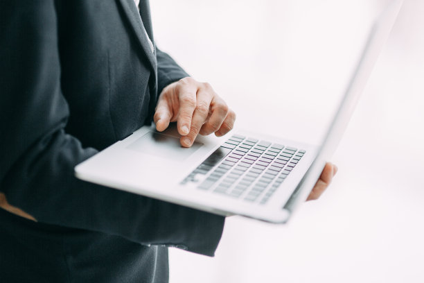 商业状况，孤立背景。在笔记本电脑上工作的手与散焦。图片下载