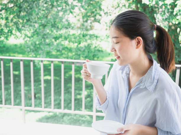 亚洲女性在阳台上喝咖啡图片下载