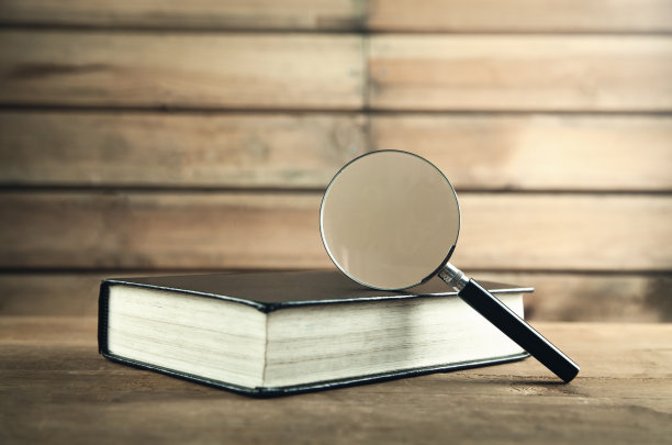 木桌上放着一个放大镜和一本书。搜索和发现图片下载