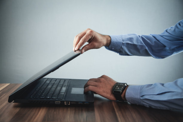 一个白人商人在书桌上打开笔记本电脑。图片下载