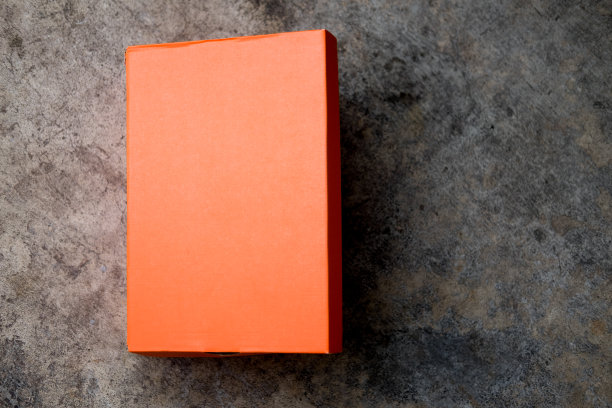 橙色鞋盒，盖子盖在水泥背景上图片下载