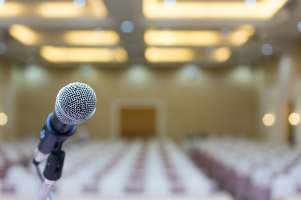 关闭了。会议室有麦克风。麦克风对着会议室背景的抽象模糊照片。图片下载