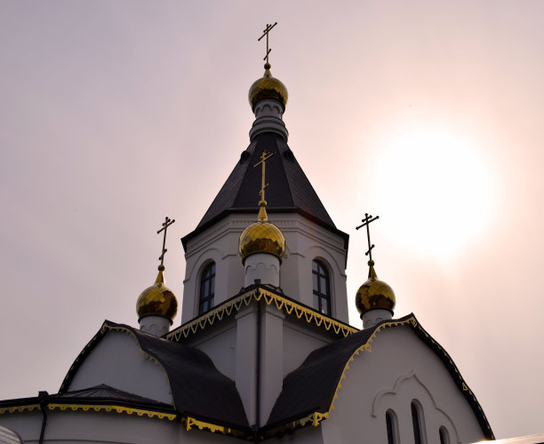 东正教乌斯本斯基修道院在克拉斯诺亚尔斯克市。森林里的基督教教堂。教堂的钟。阳光下的金色穹顶。图片下载