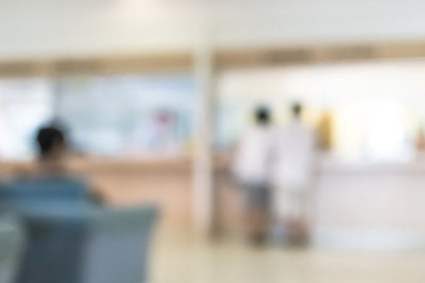 模糊医疗背景的诊所服务台大堂与病人支付账单在医院收银台图片下载