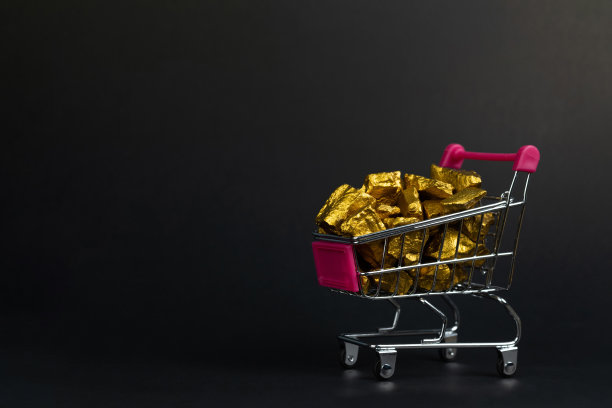 黑色背景的购物车或超市手推车上的一堆金块或金矿，宝石或一块金色的石头，财务和经营理念。图片下载