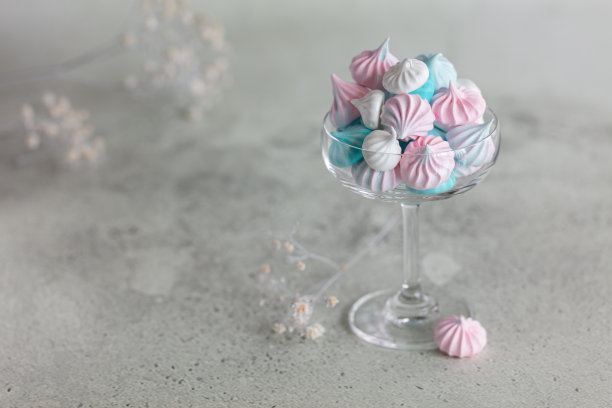 自制粉、蓝、白三色蛋白酥皮在玻璃上，以中性灰色为背景。水平简约组成图片下载