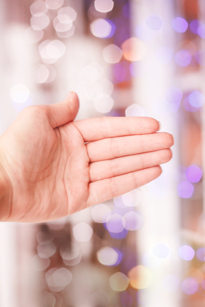 张开手在模糊的散景背景上。图片下载