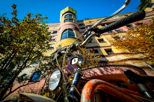 一辆锈迹斑斑的摩托车停在一座色彩斑斓的建筑前图片下载