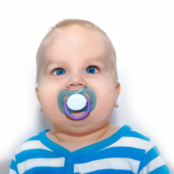 一个穿着条纹套装带着奶嘴的可爱宝宝的肖像图片下载