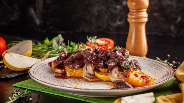 欧洲烹饪的概念。烤牛肝配焦糖水果，梨，橙子和洋葱。在餐厅里上菜。的背景图片。图片下载