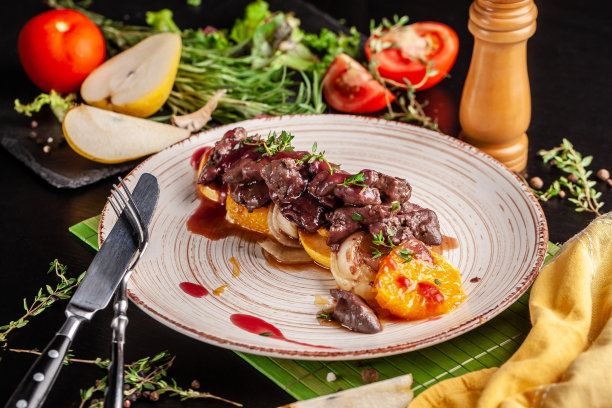 欧洲烹饪的概念。烤牛肝配焦糖水果，梨，橙子和洋葱。在餐厅里上菜。的背景图片。图片下载