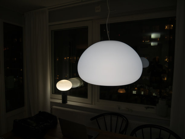 黑暗的房间里有圆形的玻璃灯。智能家居灯的光疗法。图片下载