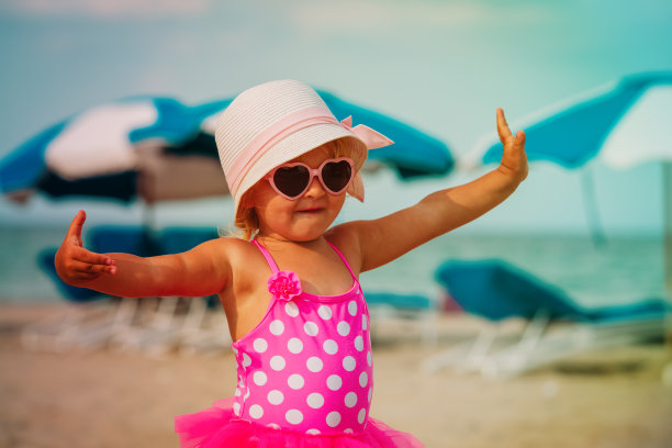 可爱的小女孩在海滩跳舞玩，家庭度假图片下载