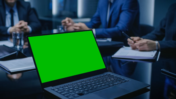 桌上的笔记本电脑上显示着绿色的模拟屏幕:一群政治家、企业商业领袖和律师坐在会议室的谈判桌前，试图达成协议。图片下载