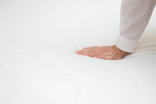 男人的手压在白色床垫上。检查硬度和柔软度。选择最好的类型和质量。副本的空间。文字或标识的空白位置。侧视图。关闭了。图片下载