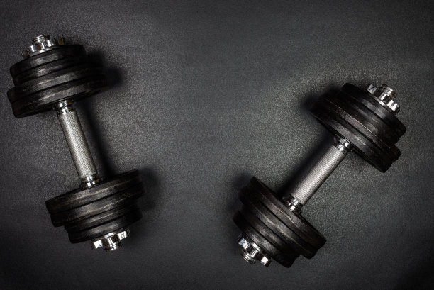 健身房的哑铃在黑色背景和复制空间，从上面拍摄的照片。图片下载