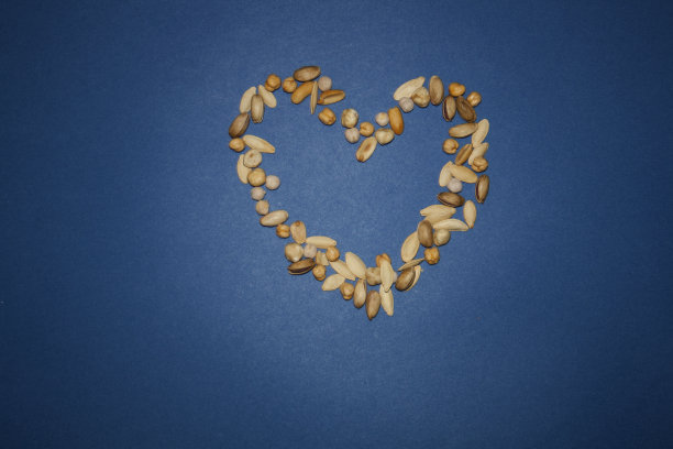 由榛子，腰果，杏仁组成，白色背景。关于装修、健康饮食和饮食背景的概念。图片下载